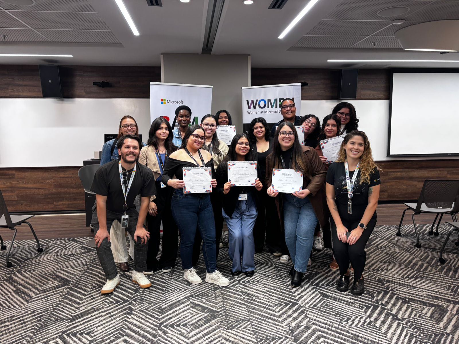 Participantes muestran sus certificados en la entrega de un programa de formación